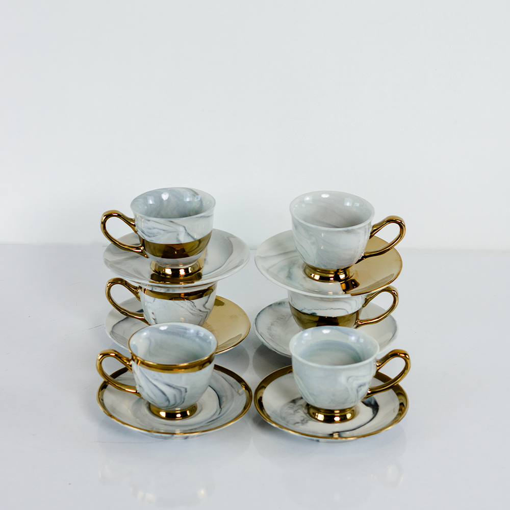 Xícara de porcelana branca com detalhes dourados luxuosos.